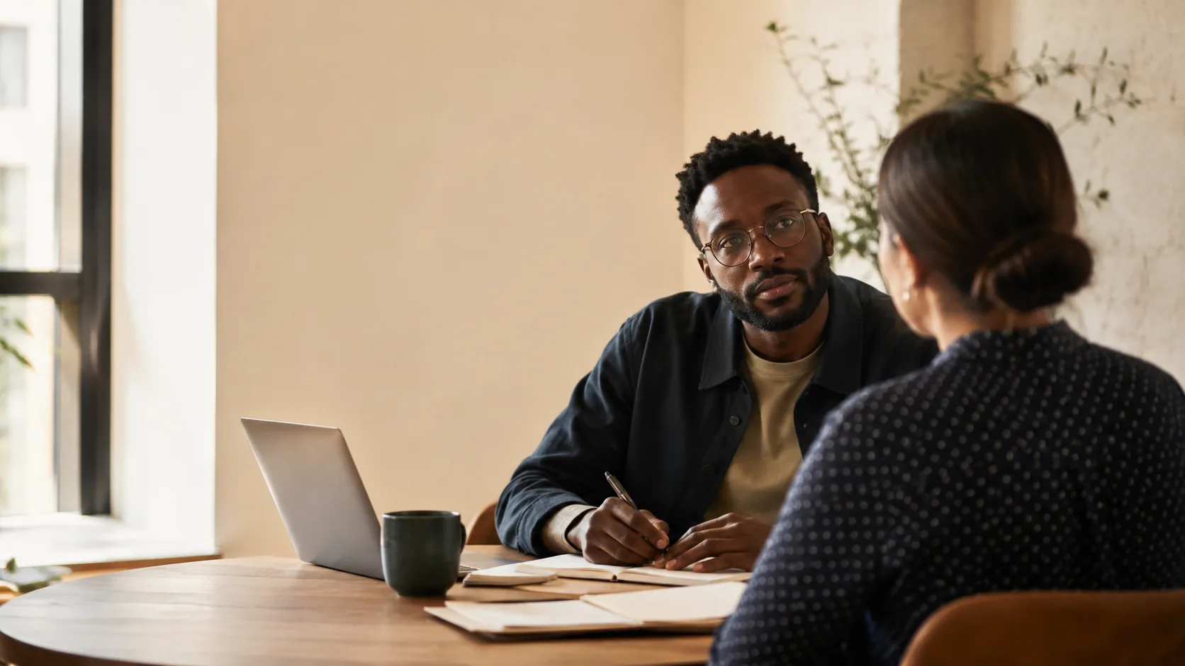 Two professionals in a thoughtful career conversation at a table